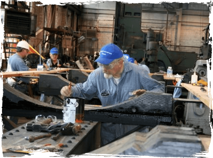 volunteer working on restoring a train part